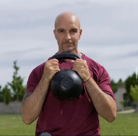 Kris Comelli, personal trainer e preparatore atletico a Parma, con un kettlebell